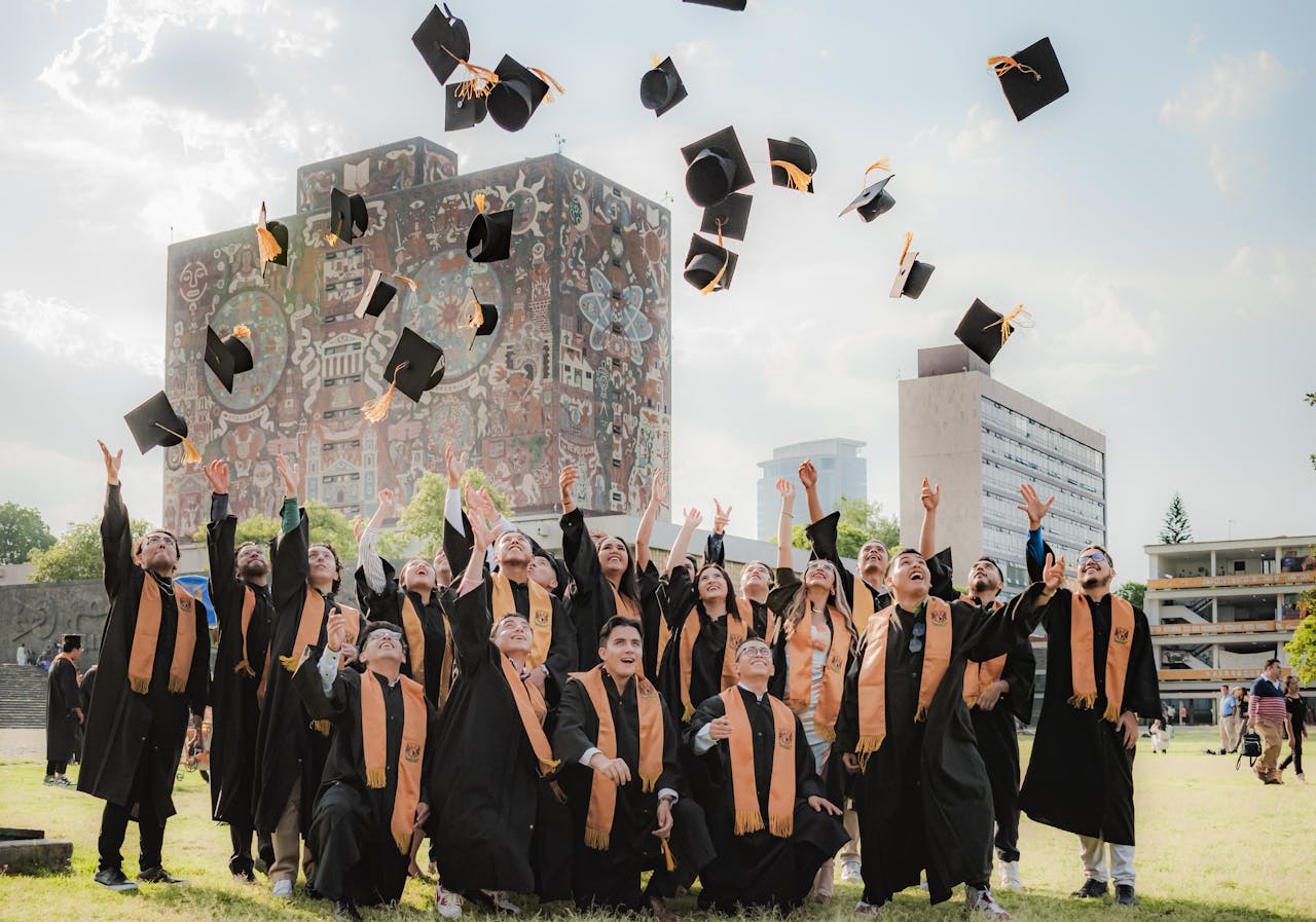 about-bg Graduates joyfully toss hats in the air by UNAM Central Library in Mexico City.